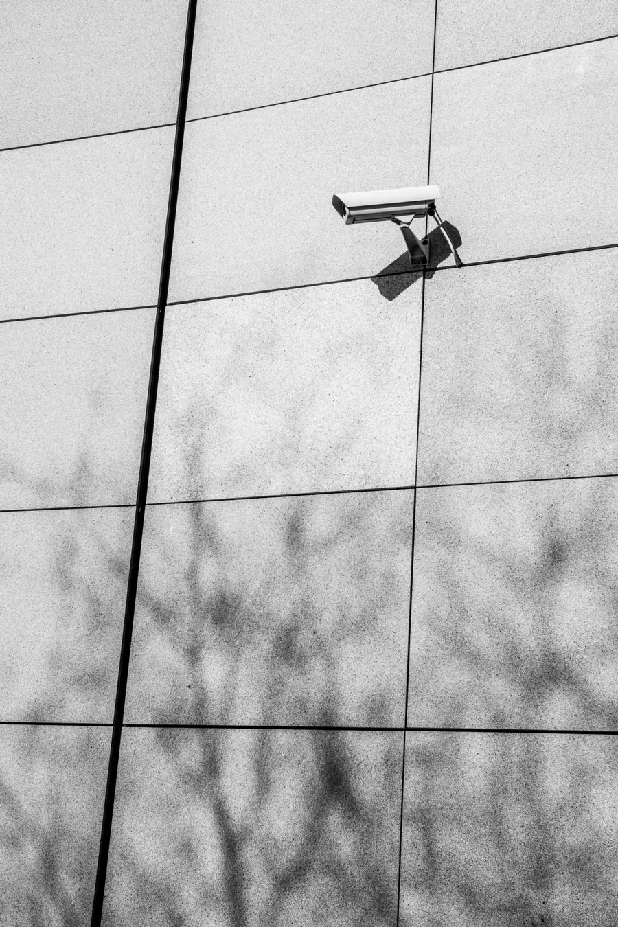 Cámara de vigilancia instalada en la fachada de un edificio, sin nadie alrededor