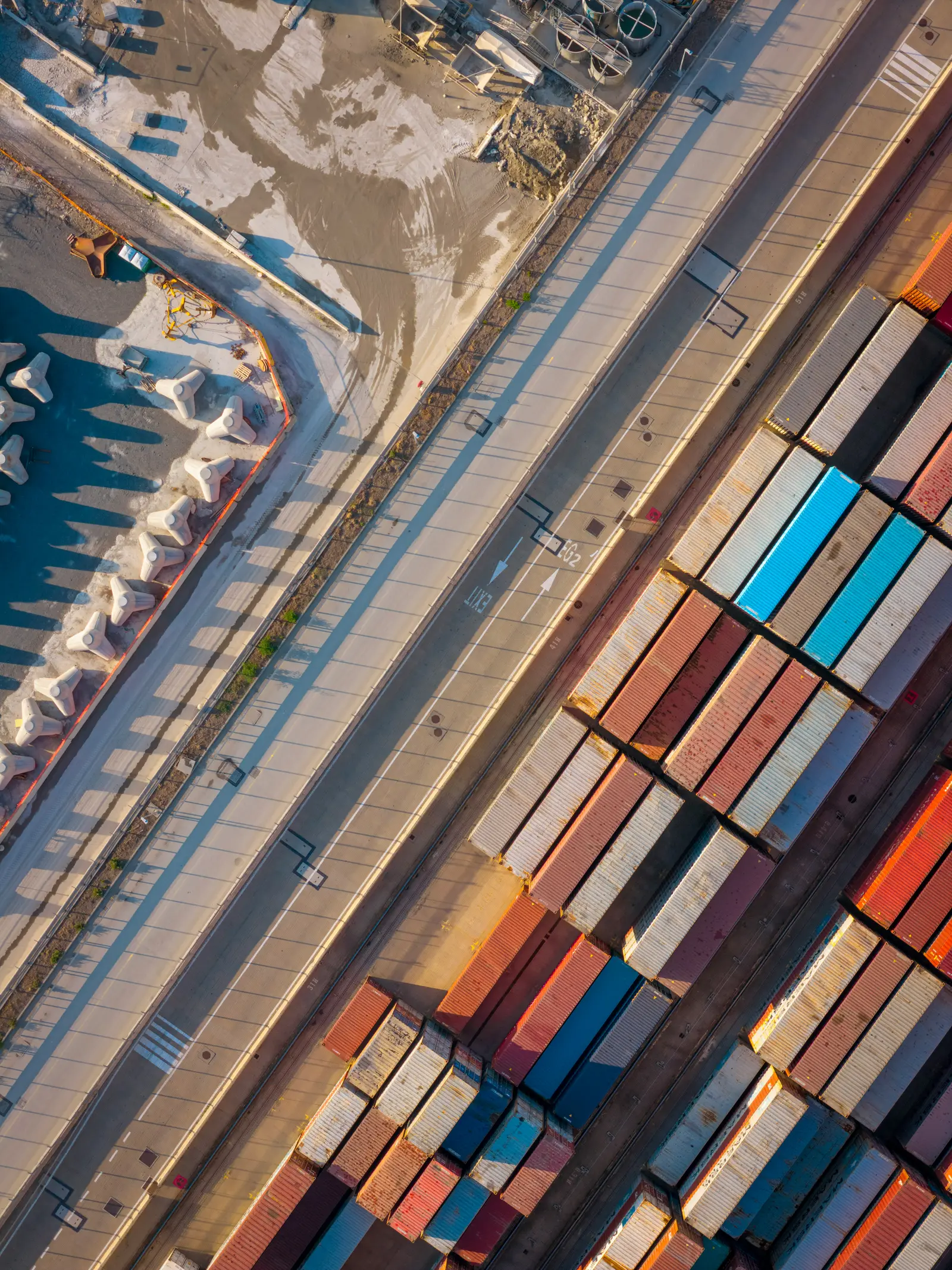 Vista aérea de contenedores apilados en un terminal portuario